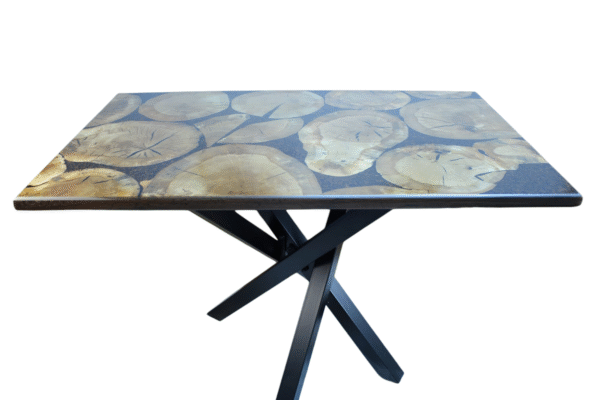 A unique and handcrafted epoxy resin table. The tabletop features a mosaic of irregularly shaped, light brown wood slices embedded within a dark brown, glossy epoxy resin. Some of the wood slices display visible tree rings and natural cracks. The resin is smooth and reflective, catching the light. The table has a dark brown wooden edge and rests on sturdy black legs. The table is a stylish, nature-inspired piece of furniture with a modern touch.