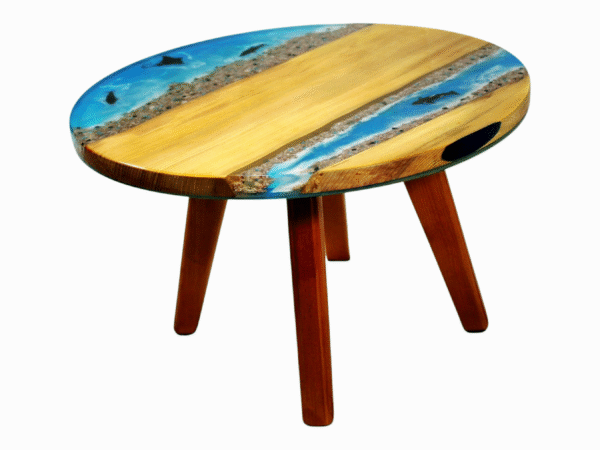 A small resin epoxy coffee table featuring a tabletop with Maple wood edges and a vibrant blue epoxy resin river in the center. Embedded within the translucent blue resin are orange starfish and dolphins, enhancing the table's beach-themed aesthetic.