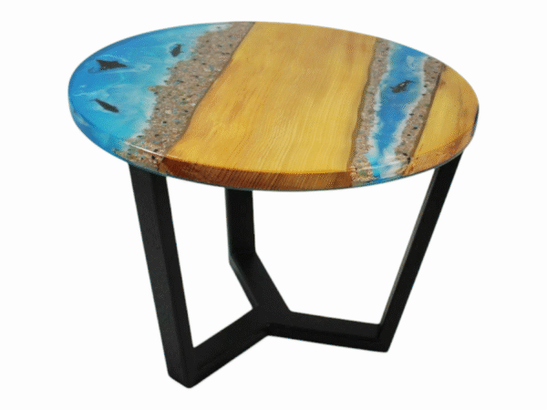 A small resin epoxy coffee table featuring a tabletop with Maple wood edges and a vibrant blue epoxy resin river in the center. Embedded within the translucent blue resin are orange starfish and dolphins, enhancing the table's beach-themed aesthetic.