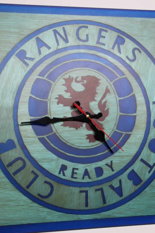A square large wall clock made of epoxy resin blue and red with black hands indicators.